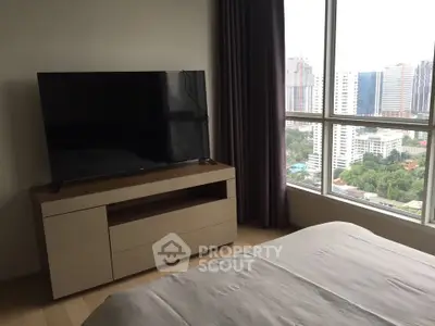 Modern bedroom with city view and sleek TV setup