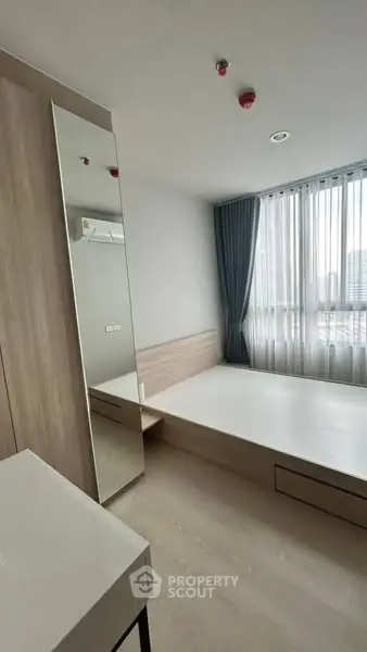 Modern minimalist bedroom with large window and sleek furniture