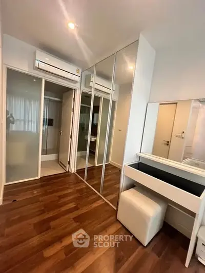 Modern bedroom with mirrored closet and wooden flooring