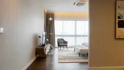 Modern living room with large windows and stylish decor, featuring a cozy seating area and contemporary furniture.