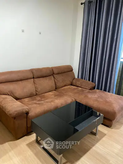Cozy living room with plush brown sofa and sleek black coffee table.