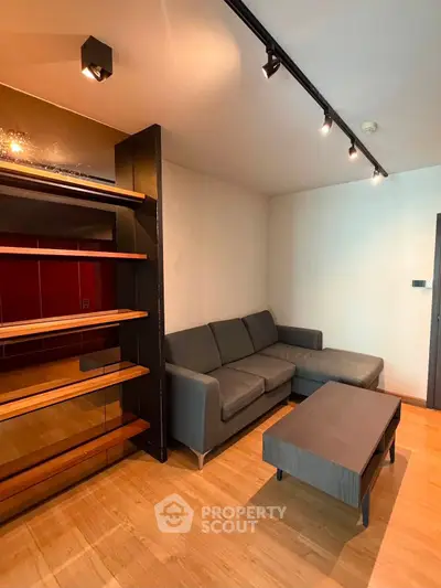 Modern living room with sleek gray sofa and stylish shelving unit