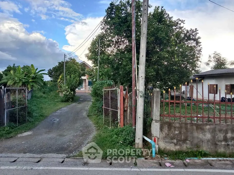 Charming rural property with lush greenery and spacious driveway entrance.