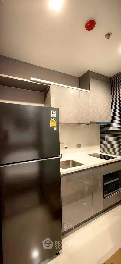 Modern kitchen with sleek appliances and stylish cabinetry in a contemporary apartment.