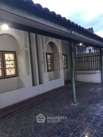 Charming exterior view of a traditional home with decorative windows and tiled patio.