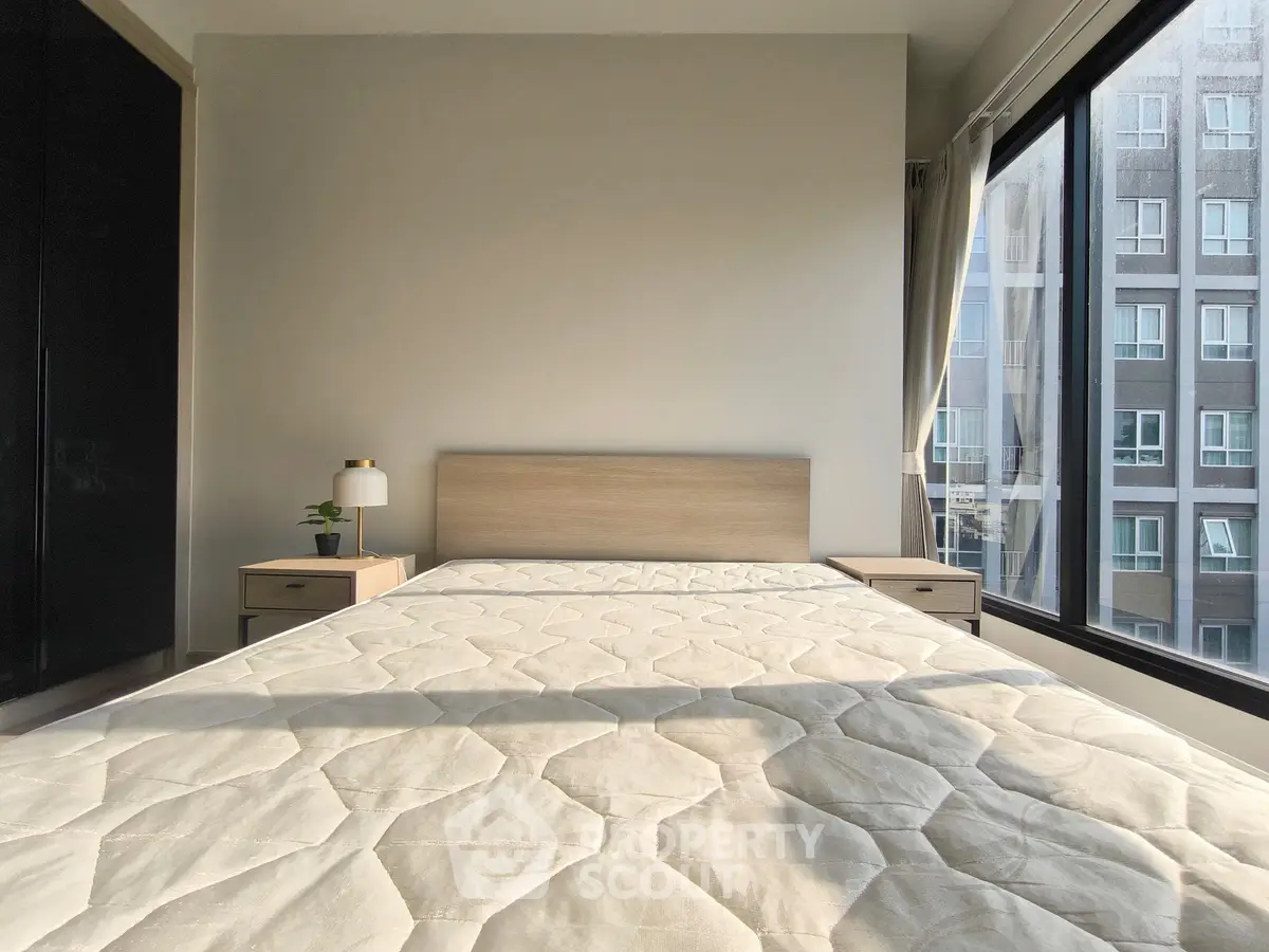 Bright and modern bedroom with large window and city view, perfect for urban living.