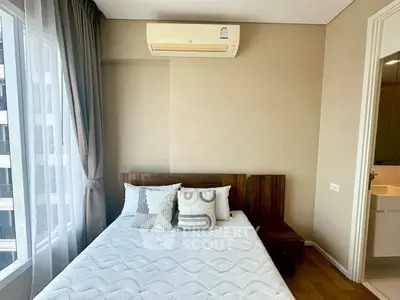 Modern bedroom with stylish decor and natural light from large window.