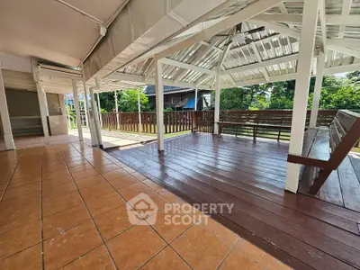 Spacious outdoor terrace with wooden flooring and garden view