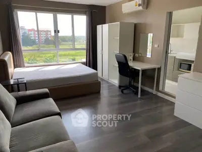 Spacious bedroom with modern furniture and large window offering scenic view