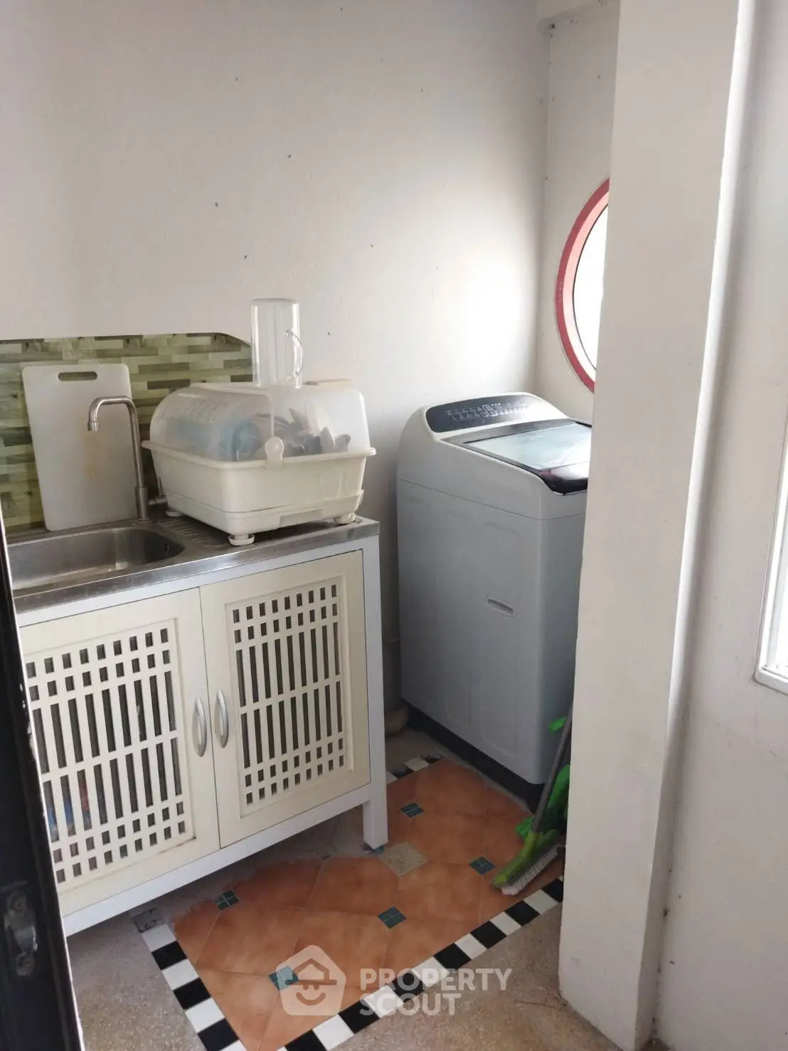 Compact laundry area with washing machine and sink in a cozy corner