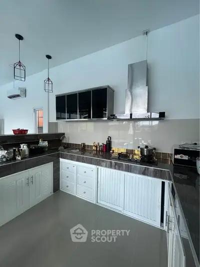 Modern kitchen with sleek cabinetry and stainless steel appliances, featuring a gas stove and ample counter space.