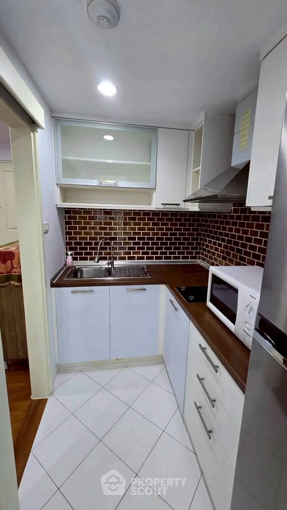 Modern kitchen with sleek cabinetry and stylish backsplash in a compact layout.