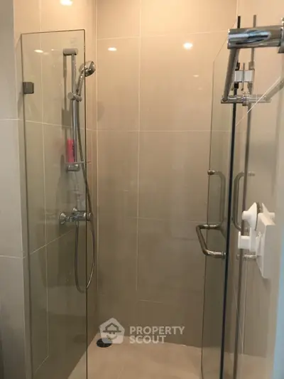 Modern glass-enclosed shower with sleek fixtures in a contemporary bathroom setting.