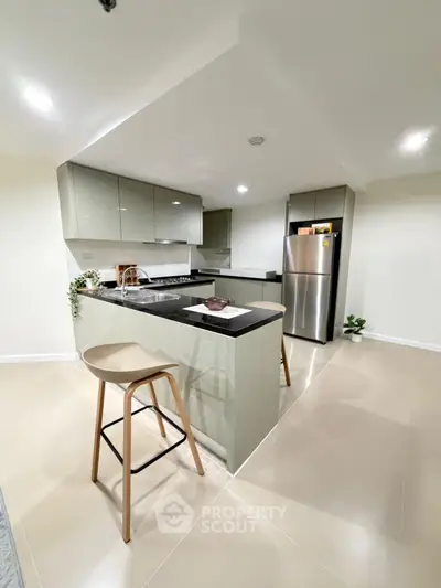 Modern kitchen with sleek design, featuring stainless steel appliances and open layout.