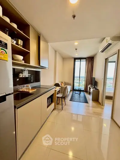 Modern open-layout kitchen and living room with sleek design and natural light.