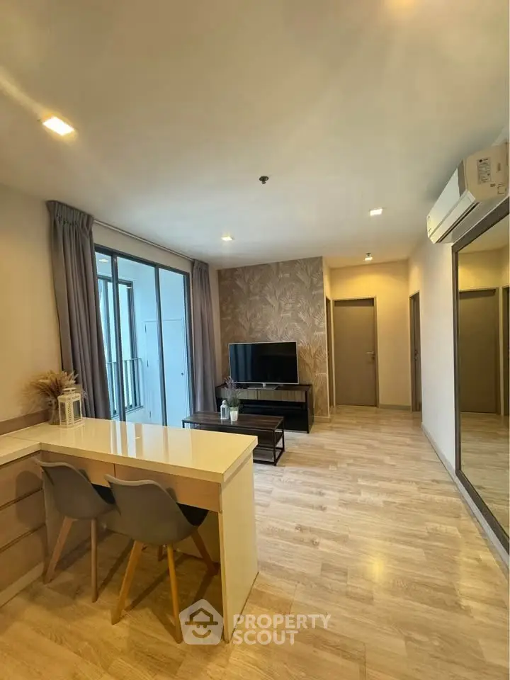 Modern living room with stylish decor and open layout, featuring a TV and dining area.