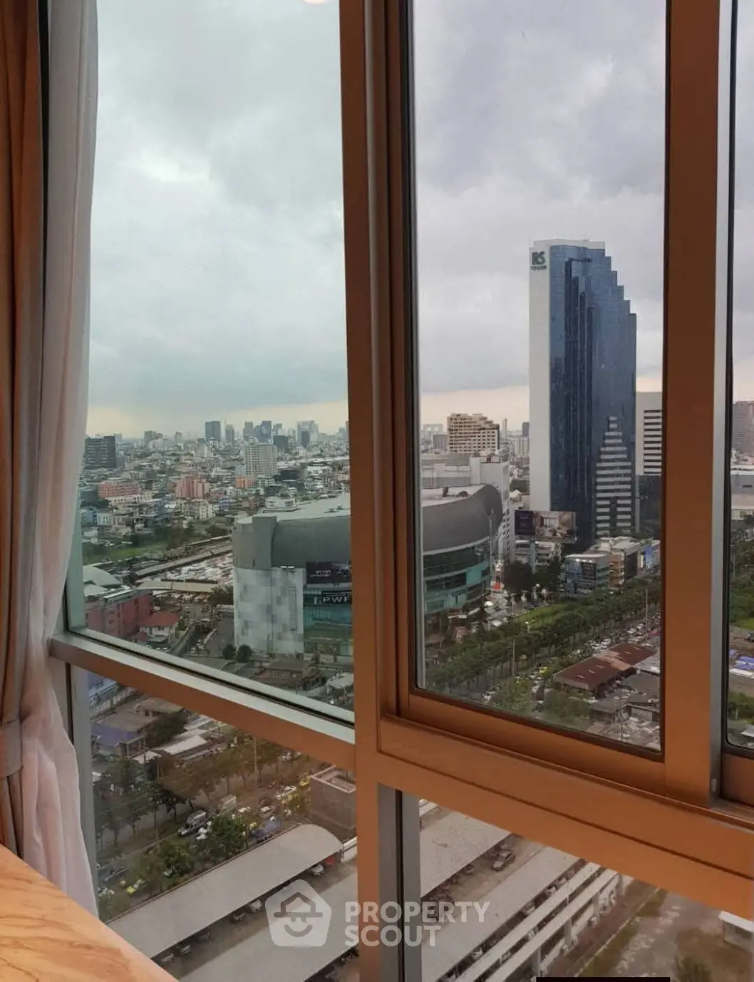 Stunning cityscape view from high-rise apartment window, showcasing urban skyline and modern architecture.