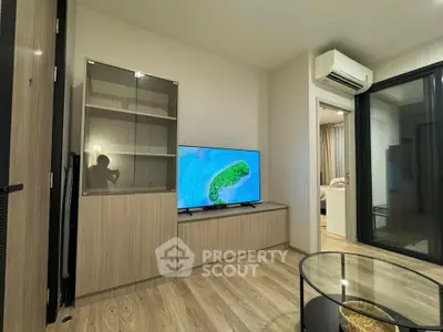 Modern living room with sleek furniture and large TV, featuring a cozy ambiance.