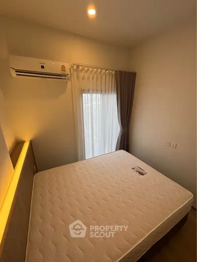 Cozy bedroom with natural light and air conditioning, perfect for relaxation.