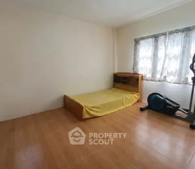 Minimalist bedroom with single bed and exercise equipment