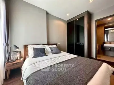 Modern bedroom with cozy decor and ensuite bathroom in a stylish apartment.