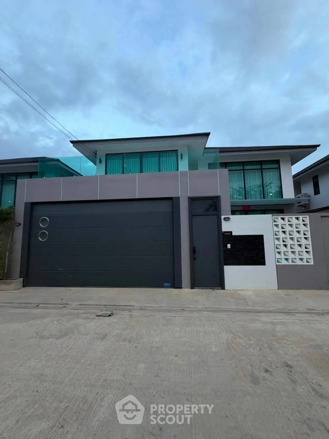Modern two-story house with sleek design and large garage in a suburban neighborhood.