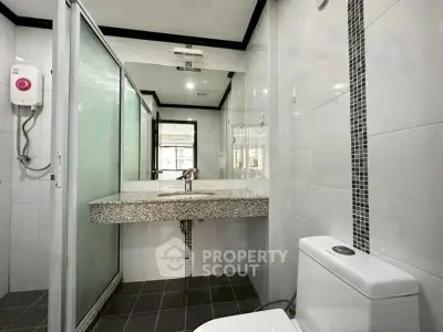 Modern bathroom with sleek design and glass shower enclosure.