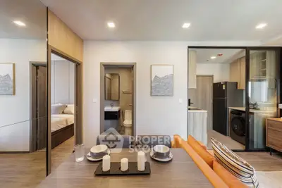 Modern open-plan living and dining area with stylish decor and integrated kitchen appliances.