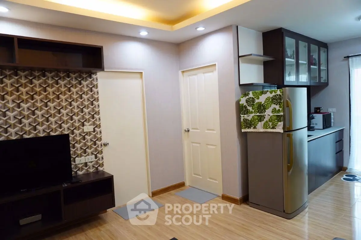 Modern living area with stylish kitchen and wooden flooring in a cozy apartment.