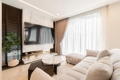 Luxurious modern living room with large TV and plush sofa, perfect for relaxation.