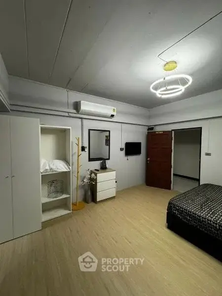 Spacious bedroom with modern lighting and ample storage in a stylish apartment.
