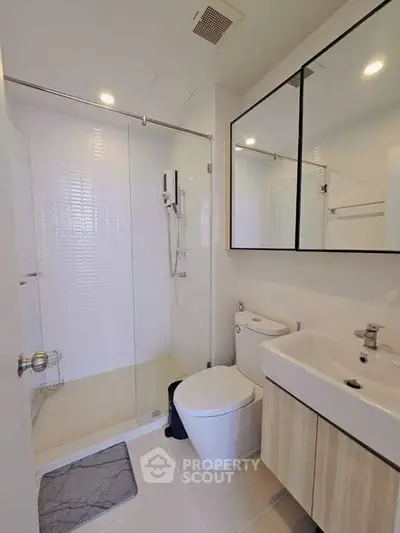 Modern bathroom with glass shower and sleek fixtures in a contemporary home.