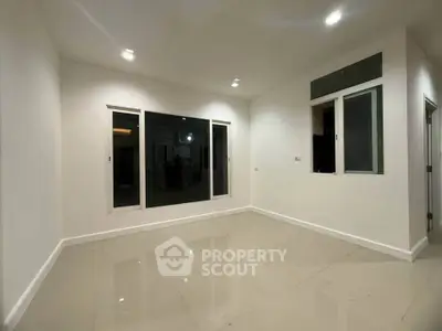 Spacious empty room with large windows and glossy tiled floor, perfect for customization.