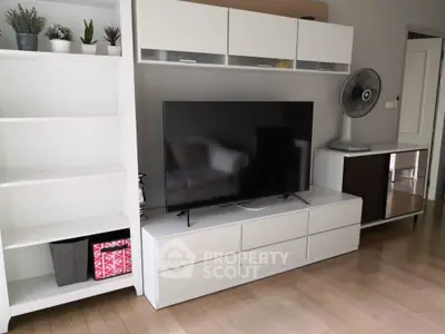 Modern living room with sleek white furniture and large flat-screen TV, perfect for stylish urban living.