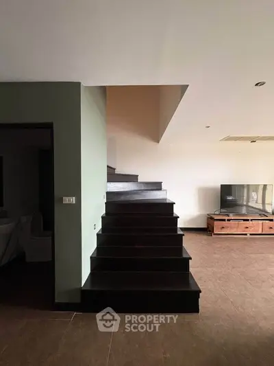 Modern interior with sleek staircase and TV unit, perfect for contemporary living.