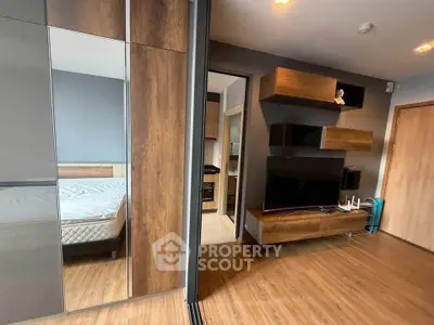 Modern apartment interior with sleek wooden flooring and stylish wall-mounted TV unit.