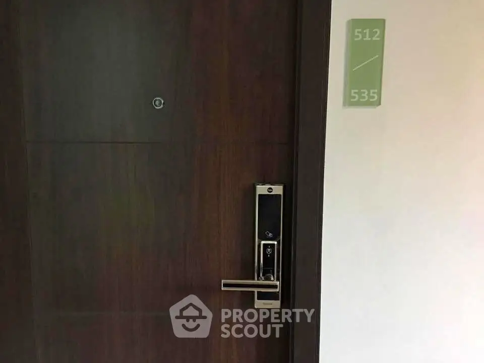 Modern apartment door with electronic lock and room number signage.