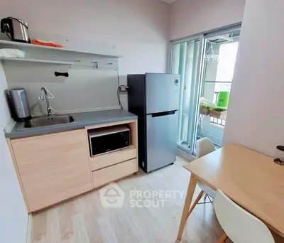 Compact kitchen with modern appliances and balcony access