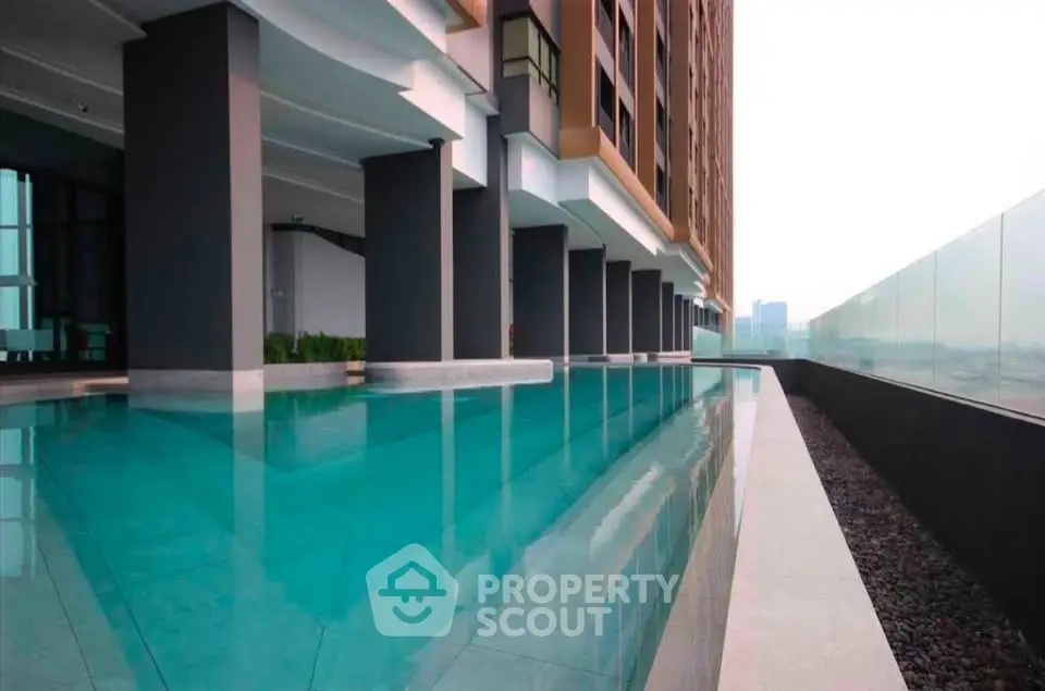 Luxurious modern building with sleek pool and stunning city view, perfect for urban living.