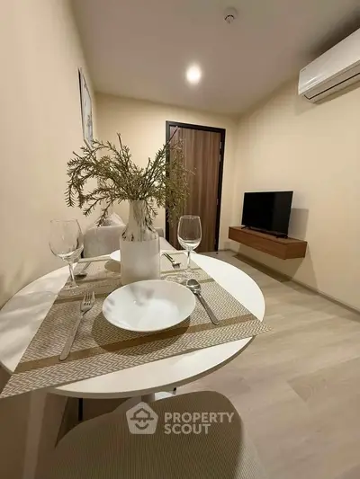 Cozy dining area with modern decor and wall-mounted TV in a stylish apartment.