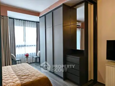 Modern bedroom with sleek wardrobe and cozy decor, perfect for urban living.