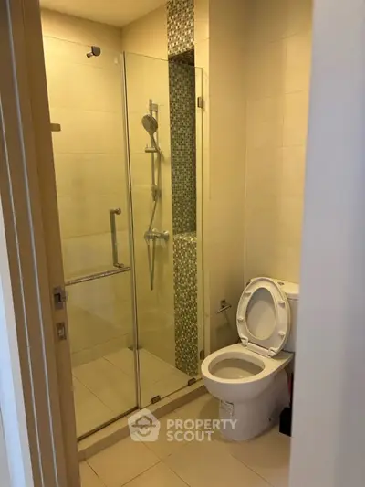 Modern bathroom with glass shower enclosure and sleek tile design.