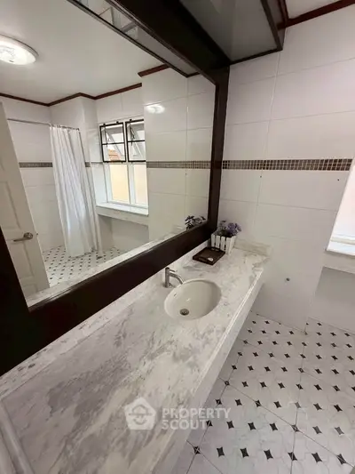 Elegant bathroom with marble countertop and large mirror