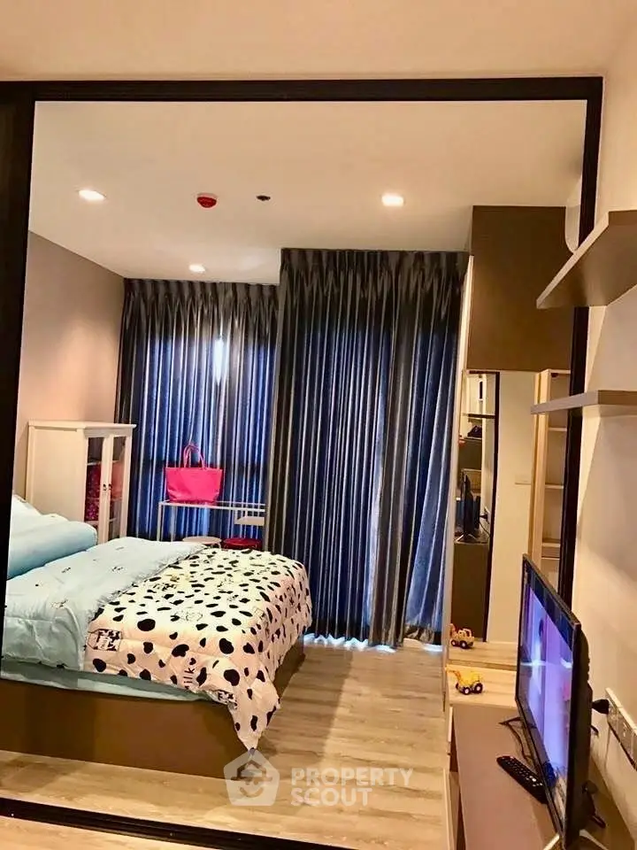 Cozy bedroom with modern decor and large window draped with elegant curtains.