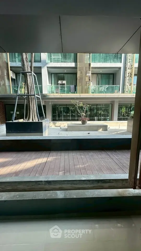 Modern apartment building with large windows and balconies overlooking a stylish courtyard.