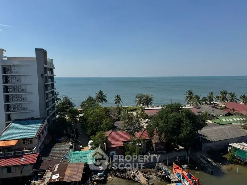 Stunning ocean view from high-rise building overlooking serene coastline and lush greenery.