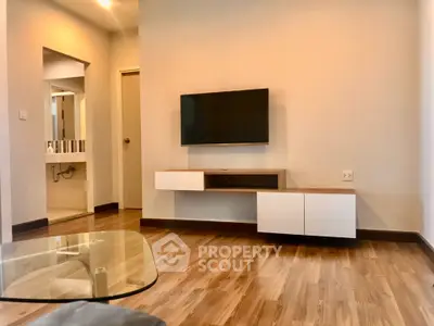 Modern living room with wall-mounted TV and stylish wooden flooring