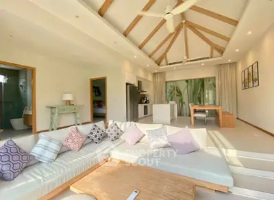 Spacious modern living room with vaulted ceiling and open kitchen layout, perfect for entertaining.