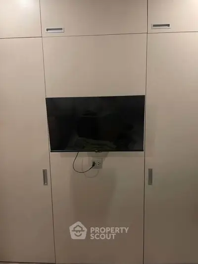 Modern built-in storage unit with integrated TV in sleek design.