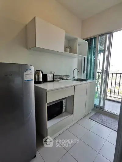 Modern compact kitchen with balcony access and sleek appliances